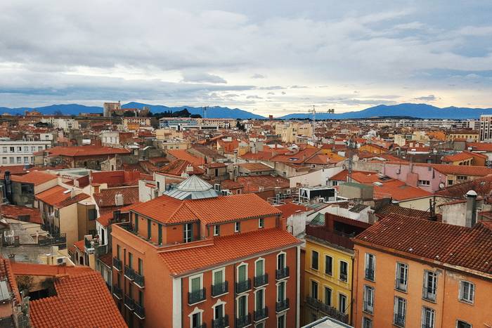 Looking out over the rooftops of Perpignan with the Pyrenees mountains in the distance